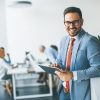 Portrait of young businessman with digital tablet in office