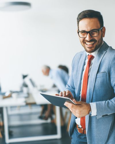 Portrait of young businessman with digital tablet in office