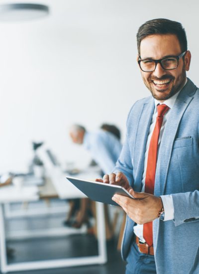 Portrait of young businessman with digital tablet in office